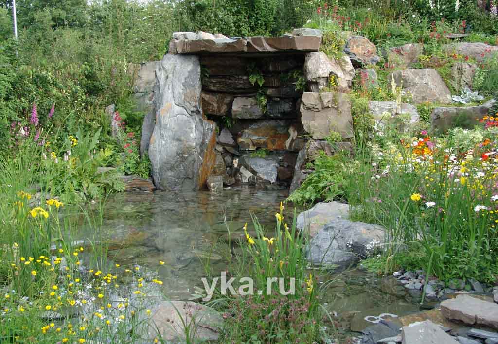 Небольшой грот над декоративным прудиком помимо подпорной функции придает всей картине романтическую загадочность.