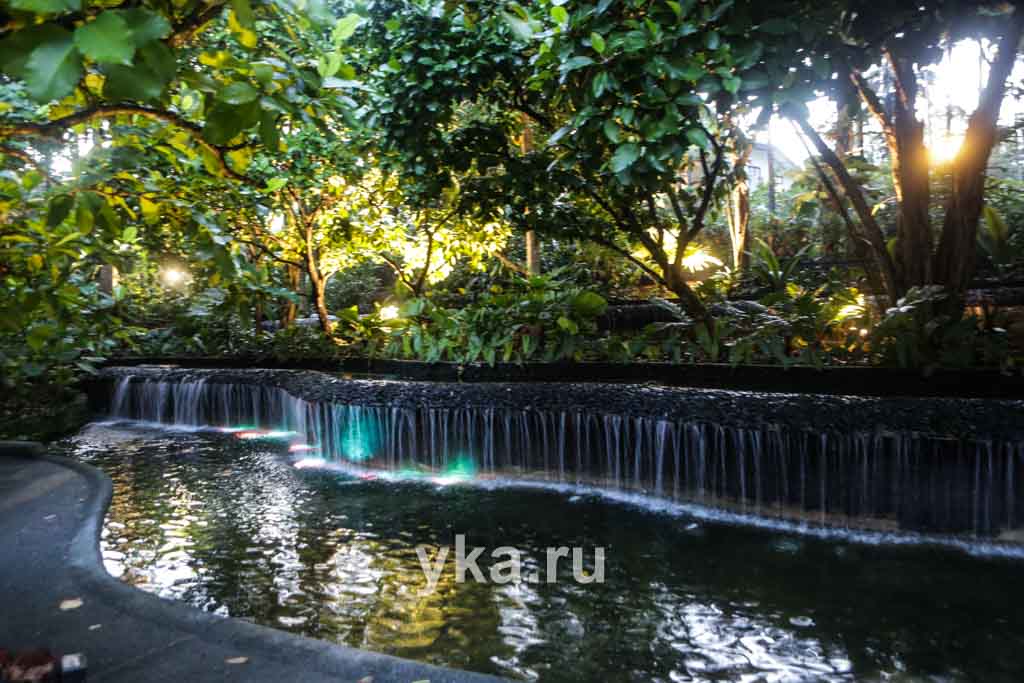 Разноцветная подсветка водоема с водопадом создает праздничное настроение.